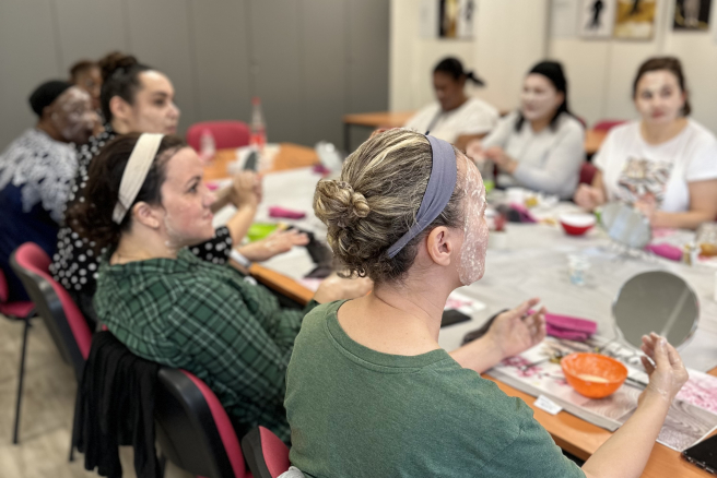 Des femmes parlent autour d'une table et de produits de beauté